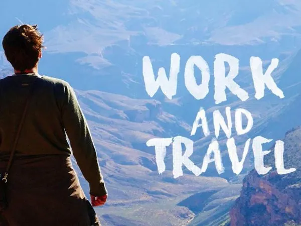 “Work and Travel” yazısı ve dağlara bakan bir kişi